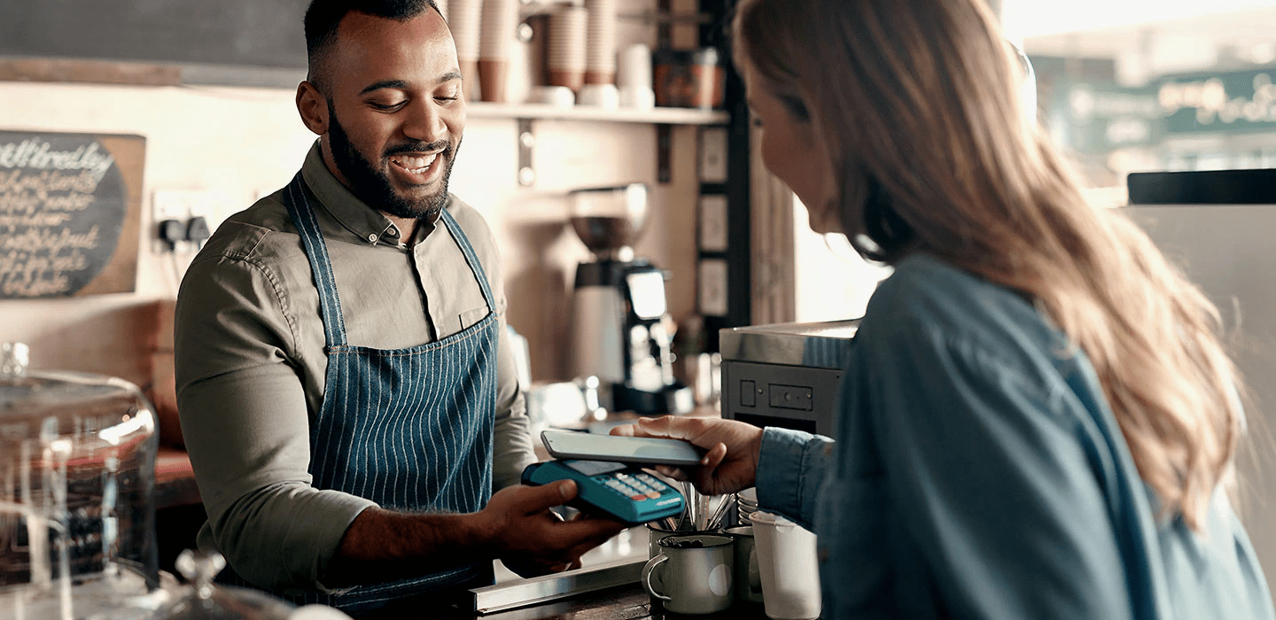 Kvinne som bruker Samsung Pay på kafé.