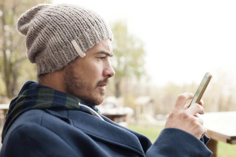 Mann som spelar på telefonen.