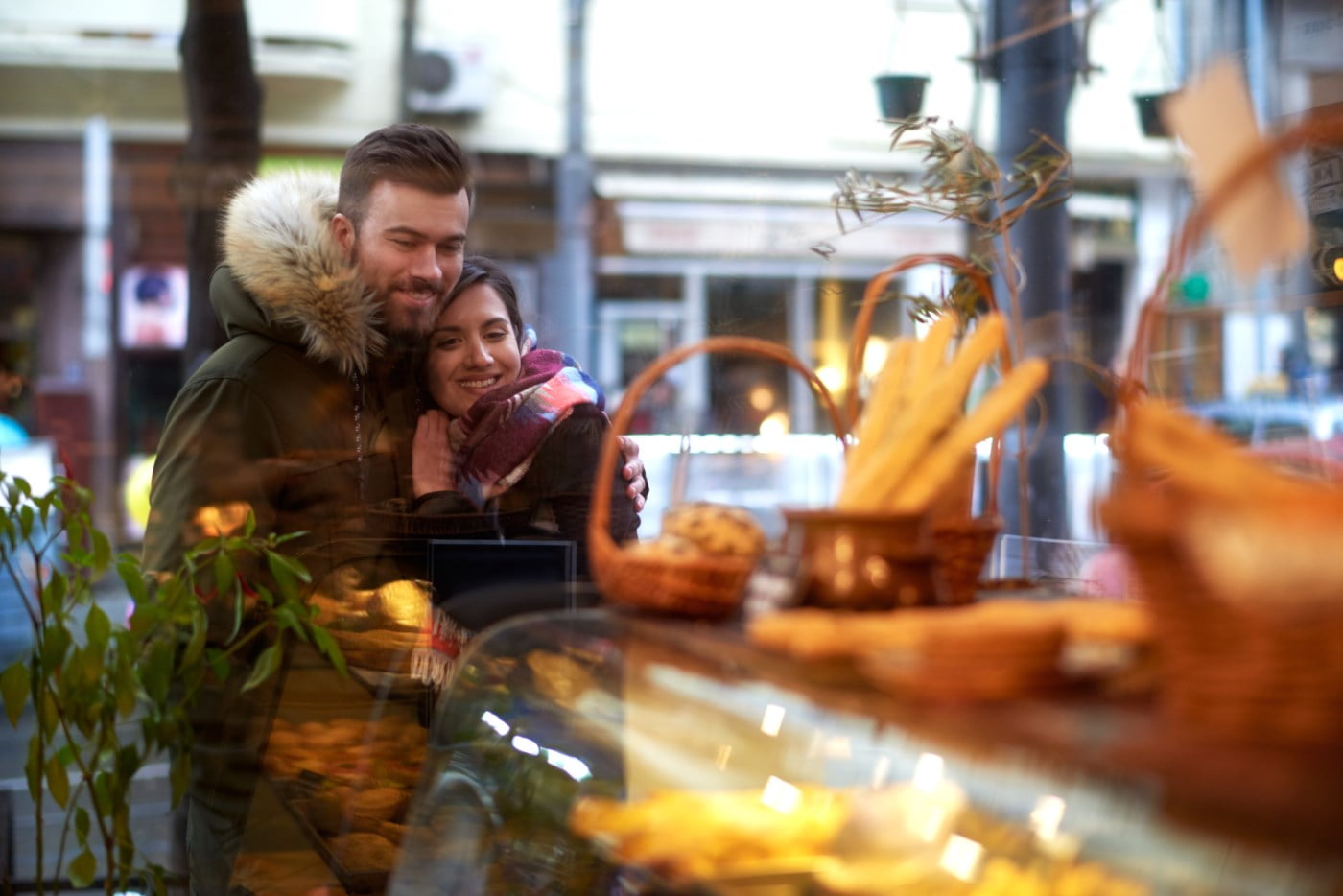 Smilande par kosar seg i eit bakeri, ein stemningsfull scene med varme smil og appetittvekkande bakverk.
